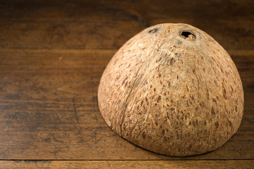 Coconut shell upside down on a wooden background closeup