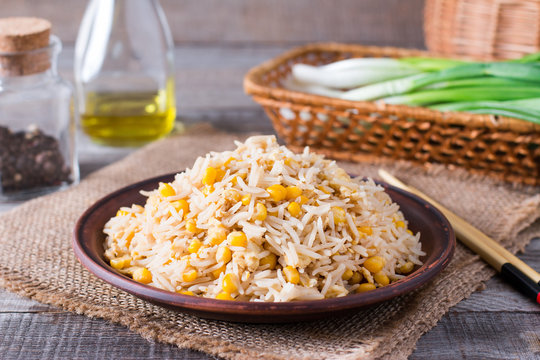 Asian fried rice with eggs and corn close-up on a plate, horizontal
