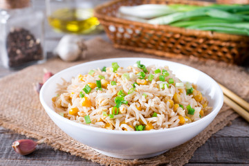Bowl of fried rice, corn and egg on a wooden background. Healthy and light.