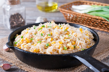 Fried rice with egg and corn. Prepared and served in a frying pan. Healthy food fried rice