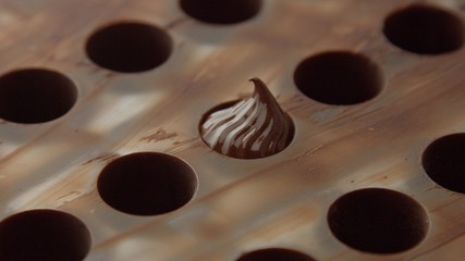 mold of chocolate candys with one hole full of cream side view