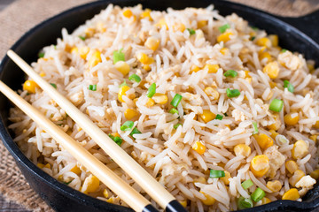 Fried rice with egg and corn. Prepared and served in a frying pan. Healthy food fried rice