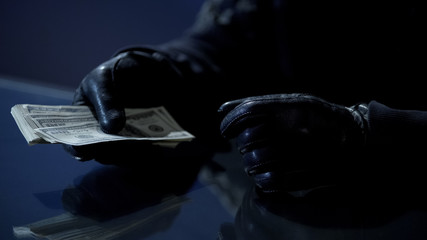 Criminal counting ransom money for kidnapping, blackmail, contract killing