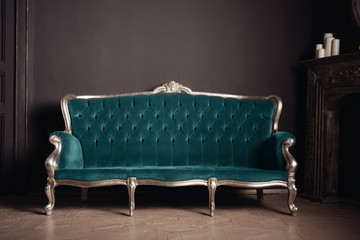 luxurious antique velor sofa turquoise color near the fireplace