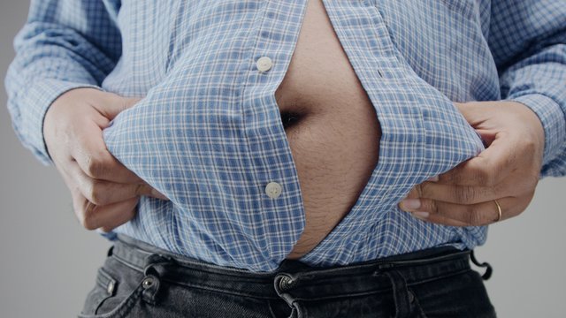 Overweight man in shrt is small to him with huge belly and open buttons