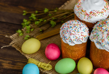 Easter cake and colorful eggs on a wooden table. It can be used as a background