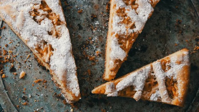 Apple pie from short pastry in the home kitchen. Pieces of half-eaten pie on a table. Homemade baking.