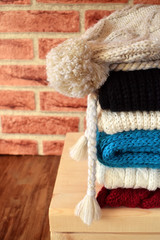 Knitted clothes of different colours are piled carefully