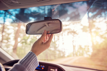 Close up Hand adjusting rear view mirror. Safety concept.