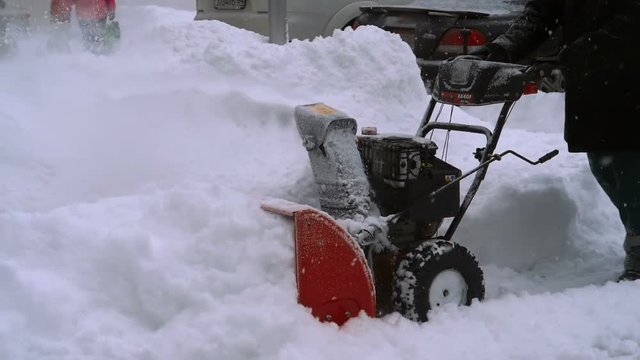 Man with a snow blowing machine working