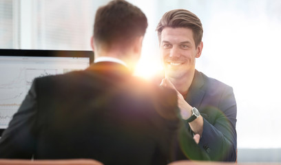 Two men discuss the growth of the company, looking at the rising