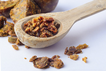 Propolis granules in a wooden spoon. Bee glue. Bee products. Apitherapy. Apiculture.