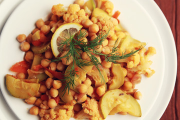 Vegetable stew with chickpeas, cauliflower and cabbages. Close up. Top view. Vegan dish. European cuisine. Vegetarian lunch. Toned photo.