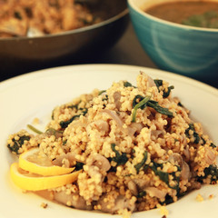 Millet with mushrooms and spinach. Jewish cuisine. Vegetarian couscous on the round white plate. Close up. Toned photo.