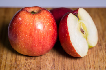 Naklejka na ściany i meble Three red apples with shadow on a wooden board