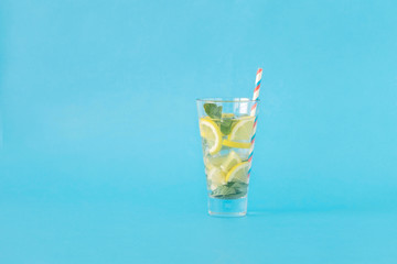 Refreshing summer cocktail with lemon and mint on blue background