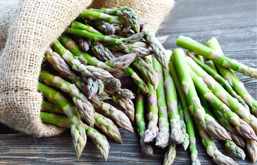 Asparagus or garden asparagus in sack bag on wooden floor