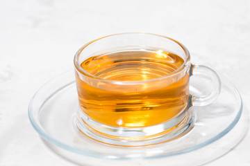 fragrant tea in a glass cup on a white background, closeup