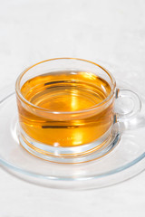 fragrant tea in a glass cup on a white background, vertical closeup