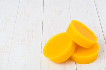 Pieces of natural beeswax on a wooden background. Beekeeping products. Apitherapy.