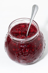 jar with cowberry jam on white background, vertical top view