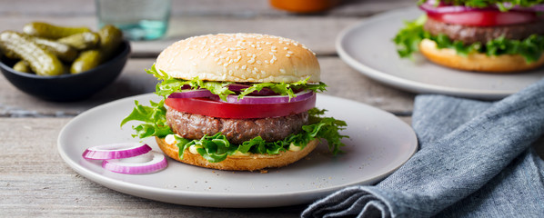 Burger on a plate. Wooden background. Copy space.