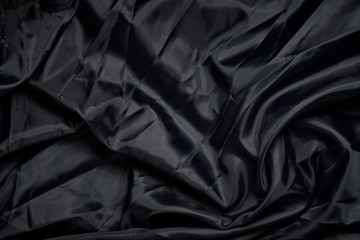 Smooth elegant deep black silk or satin luxury cloth texture. Retro style.