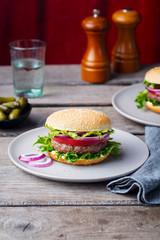 Burger on a plate. Wooden background. Copy space.