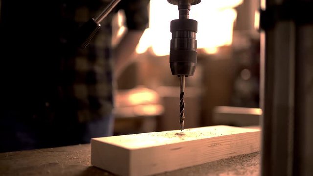 Handsome man in his fourties working with wood in his workshop