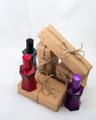 Stack of handcraft gift boxes nad parfume glasses on white background