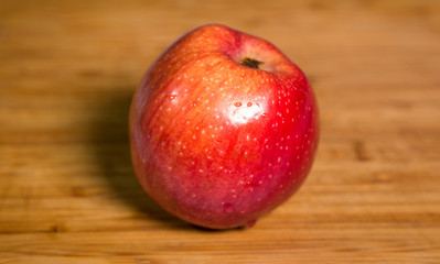 Fototapeta na wymiar Red apple with shadow on a wooden board