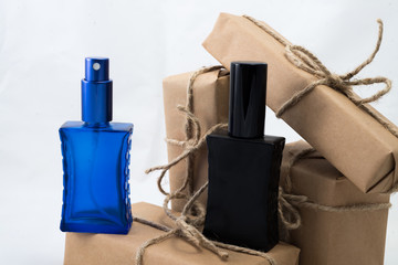 Stack of handcraft gift boxes nad parfume glasses on white background