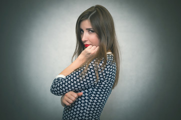 Sad offended and disappointed woman is thinking isolated on gray background.
