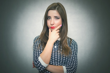 Serious offended and disappointed woman is thinking isolated on gray background.