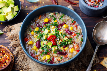 Vegetable quinoa soup, stew with avocado, corn, beans. Top view.