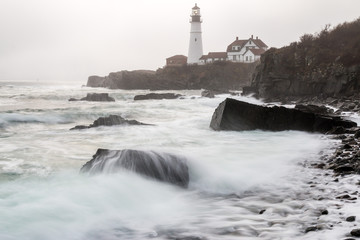 The tide rolling in during a foggy morning at Portland Head Lighthouse. 