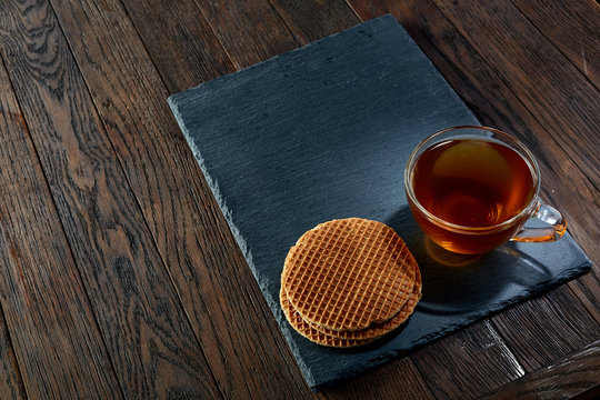 Cup of tea with meringues on a wooden background, top view