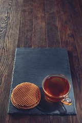 Obraz na płótnie Canvas Cup of tea with meringues on a wooden background, top view