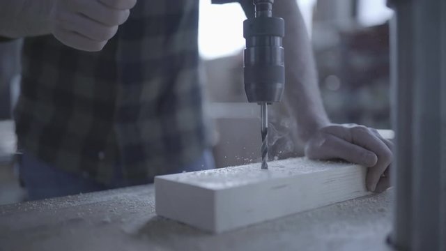 Handsome man in his fourties working with tools and wood at his workplace