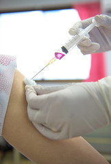 Soft focus nurses are vaccinations to patients using the syringe.Doctor vaccinating women in...