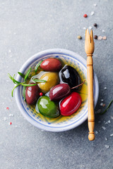Olives assortment in bowl with oil. Top view. Copy space.