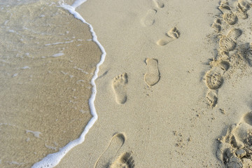 Lonely, Footprints in the sand of a beach by the Mediterranean sea on the island of Ibiza in Spain, holiday and summer scene