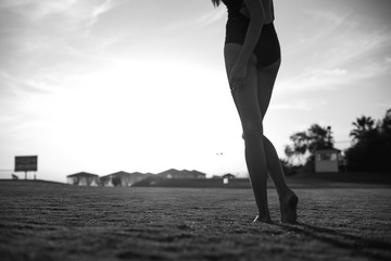 happy beautiful woman in bikini on the green grass on sunset.