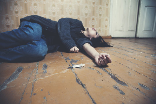 sad woman lying floor and needle