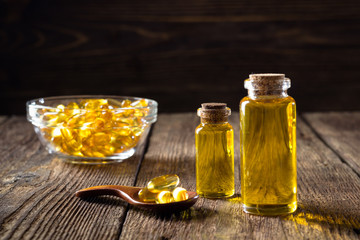 Fish oil capsules on wooden background, vitamin D supplement - obrazy, fototapety, plakaty
