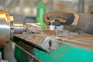 The detail is clamped by clips on a table. Dry boring by a trailer mill with a smoke and steam. The look with a side, the worker operates manufacturing process at plant.