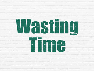 Time concept: Painted green text Wasting Time on White Brick wall background