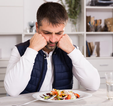 Sadly Young Man Before Eating Vegetable Salad From Plato