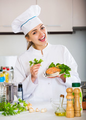 Happy young cook with prepared trout in plate