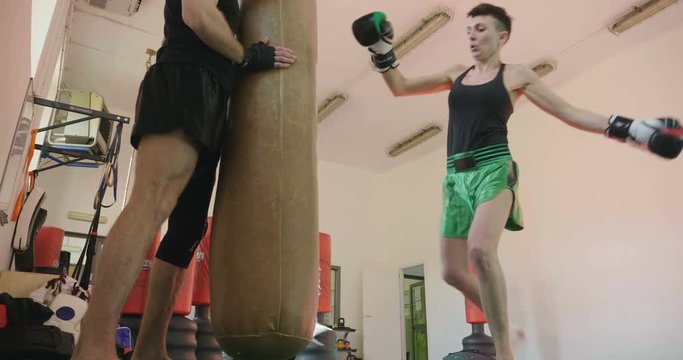 A woman trains himself in the gym performing both free-body exercises, such as push-ups and abdominals, and exercises with rocker arms and professional equipment. Concept of: sport, power, muscles.
